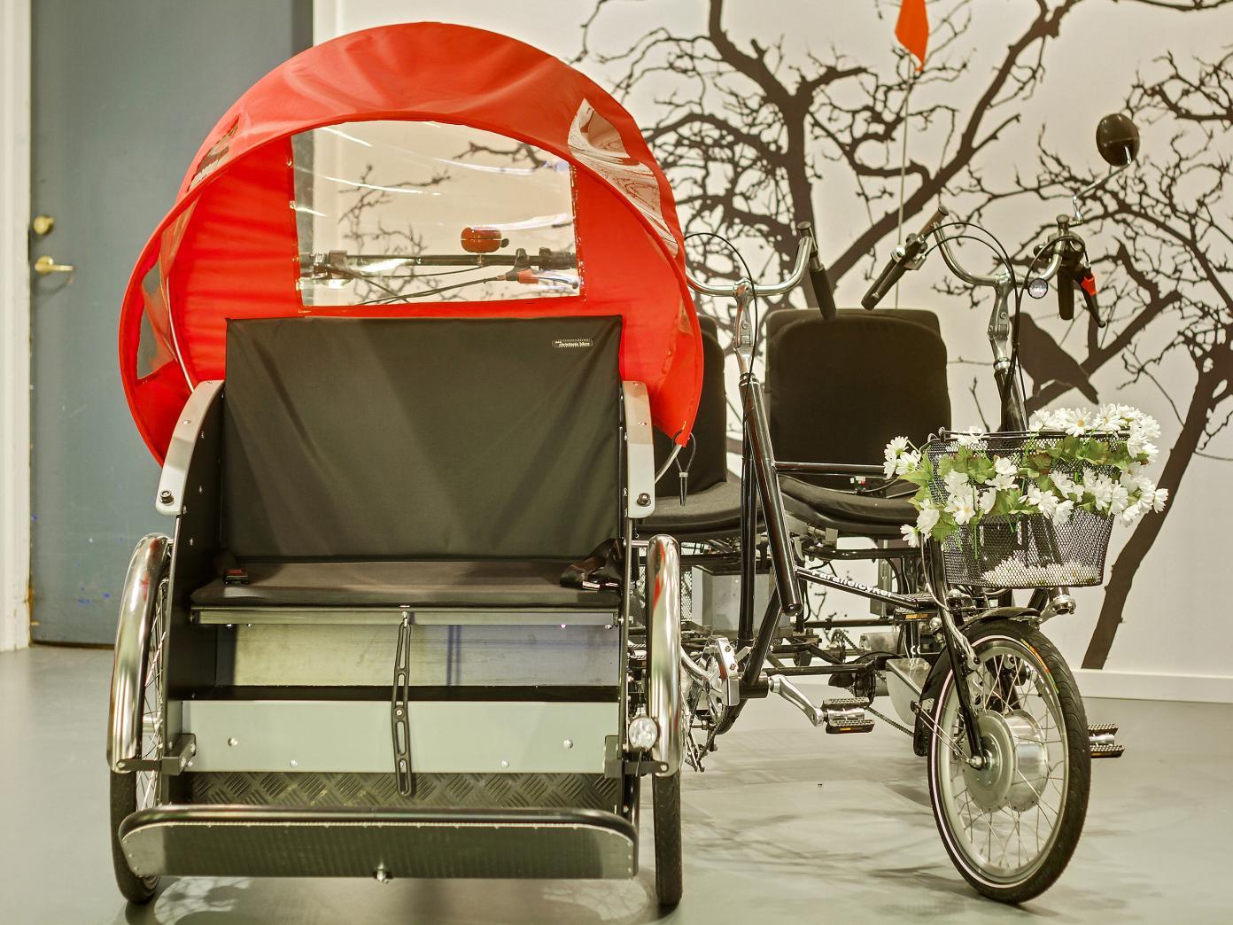 To cykler – en rickshawcykel, som er en moderne ladcykel til persontransport, og en duocykle med plads til to cyklende – parkeret indenfor.