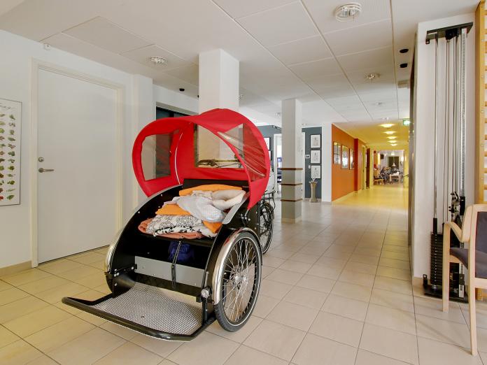 Gangareal, hvor en rickshaw, en moderne ladcykel til persontransport, står parkeret.