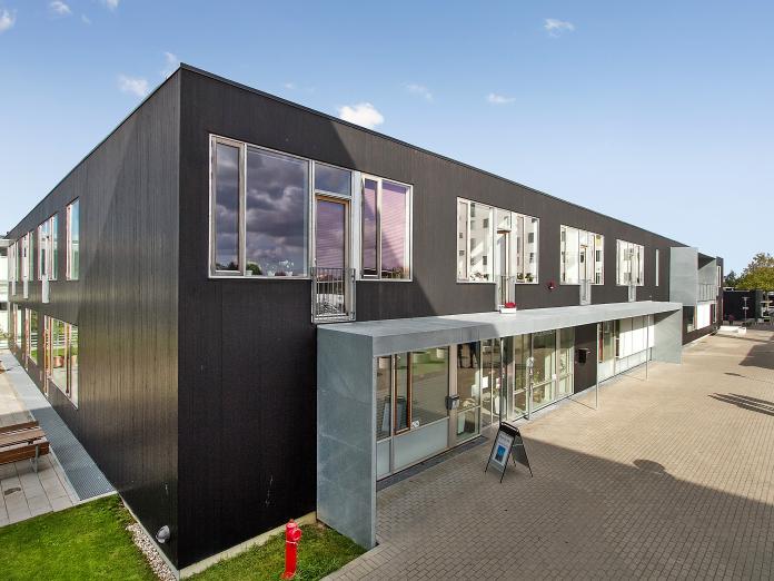 Bomi-Parkens firkantede, sorte bygning set fra gaden.