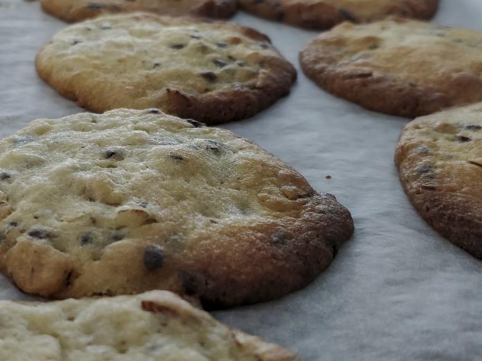 Nybagte, lyse cookies på bagepapir. 