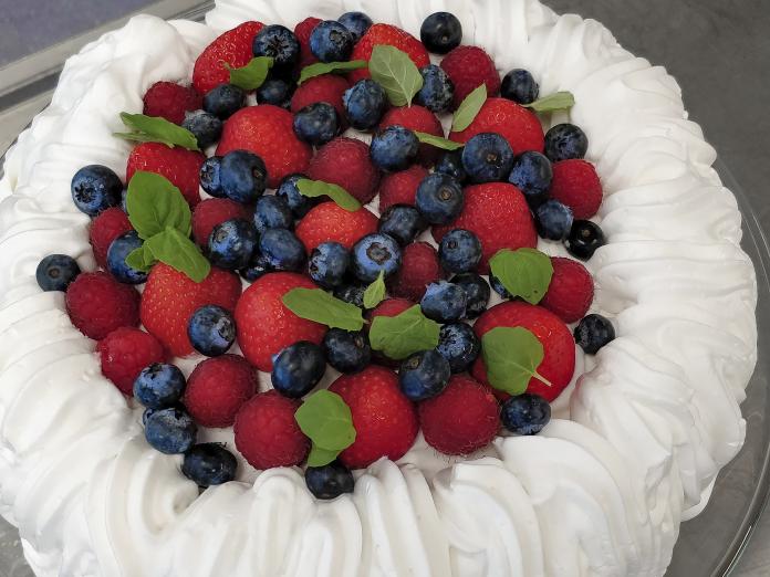 Lagkage med flødeskum, jordbær, blåbær og friske mynteblade.