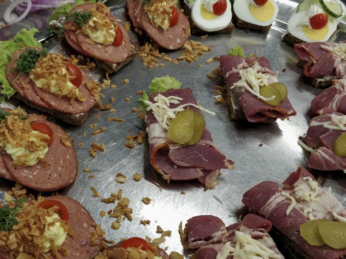 Fad med smørrebrød blandt andet spegepølse med ristede løg og æggemadder med tomat og mayonnaise. 