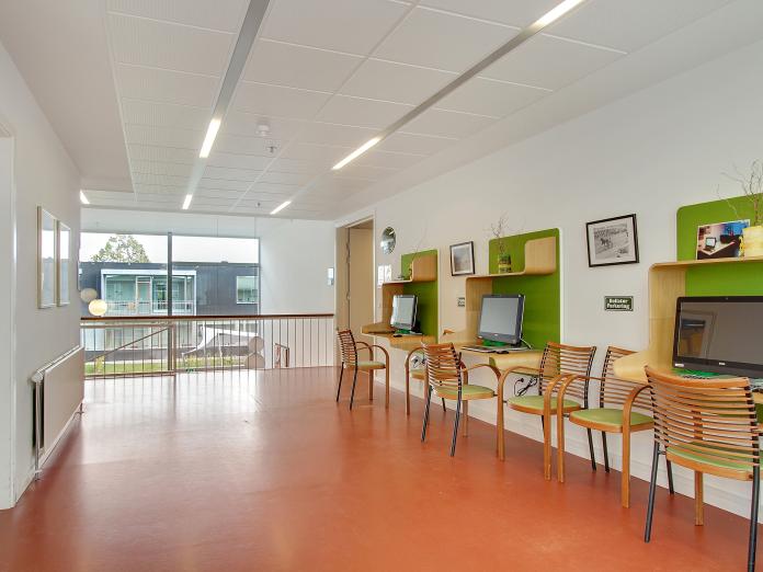 Fælles computerrum med tre computere og endnu flere stole. 