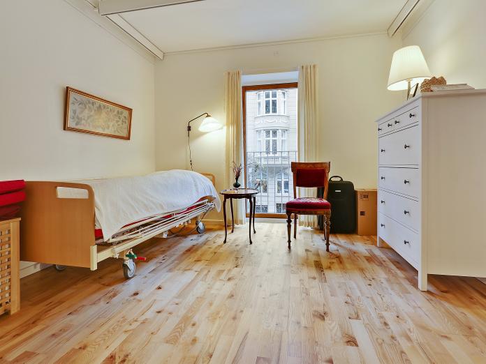 Soveværelse med seng, loftslift og møbleret med personlige møbler.