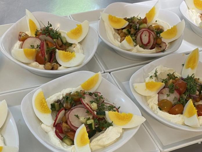 Anretning på dybe tallerkner med bl.a. æg og radiser.